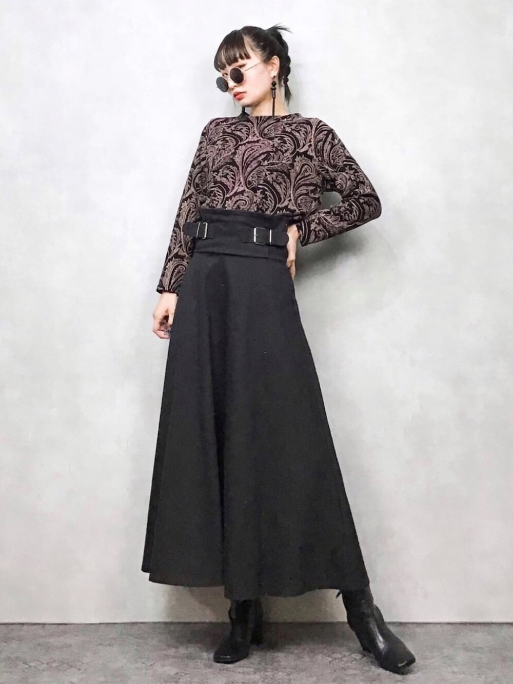 ブラック系のスカート、ブラック系のブーツ、その他のTシャツ/カットソーを着用したレディースの春コーディネートの1枚目の写真