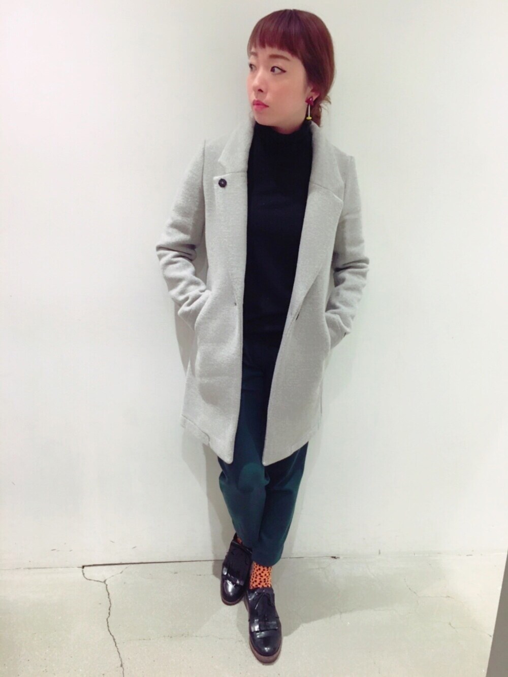 ブラック系のニット/セーター、グレー系のステンカラーコートを着用したレディースの冬コーディネートの1枚目の写真