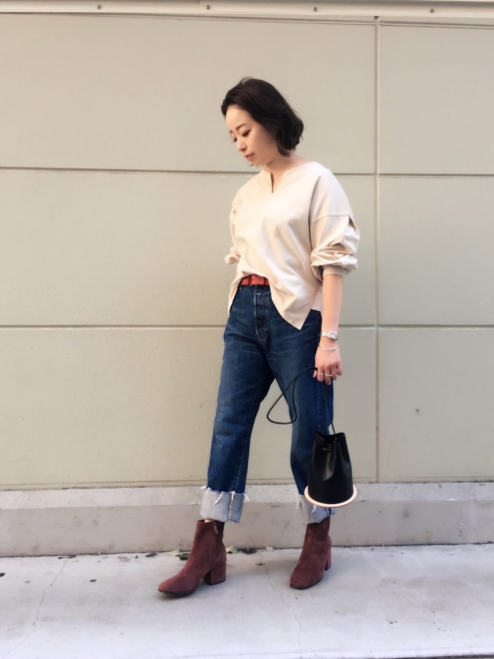 ベージュ系のTシャツ/カットソー、ブルー系のデニムパンツを着用したレディースの秋コーディネートの1枚目の写真