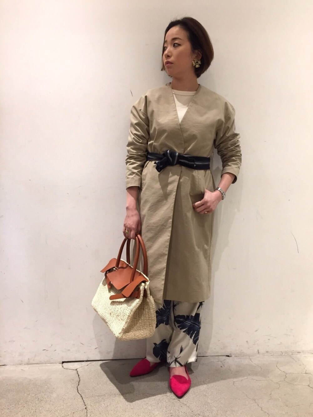 ホワイト系のTシャツ/カットソー、ベージュ系のステンカラーコート、ベージュ系のかごバッグを着用したレディースの冬コーディネートの1枚目の写真