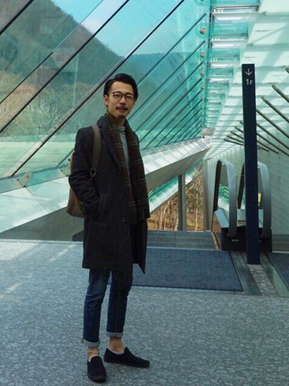 「カジュアル、黒、革靴、outfit、ニット、マフラー、チェスターコート、デニム、スニーカー」｜「SKAGENのKROYER BACKPACK　SMH0095（バックパック/リュック、グリーン系）」を使った、takekazu3さん（メンズ・167cm）の春コーディネートの1枚目の写真