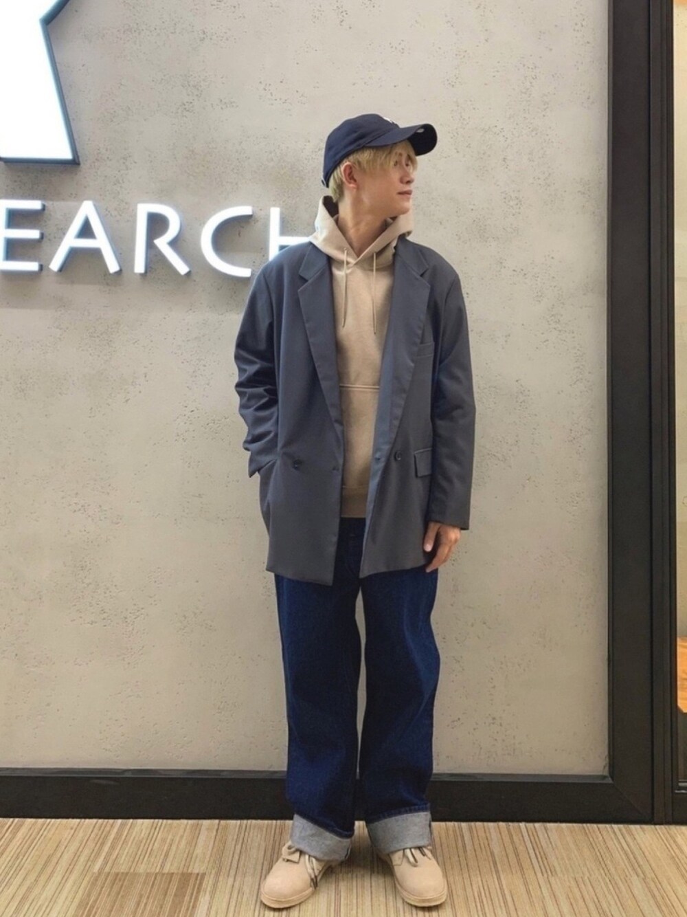 ブラウン系のパーカー、グレー系のテーラードジャケット、ブルー系のデニムパンツを着用したメンズの冬コーディネートの1枚目の写真
