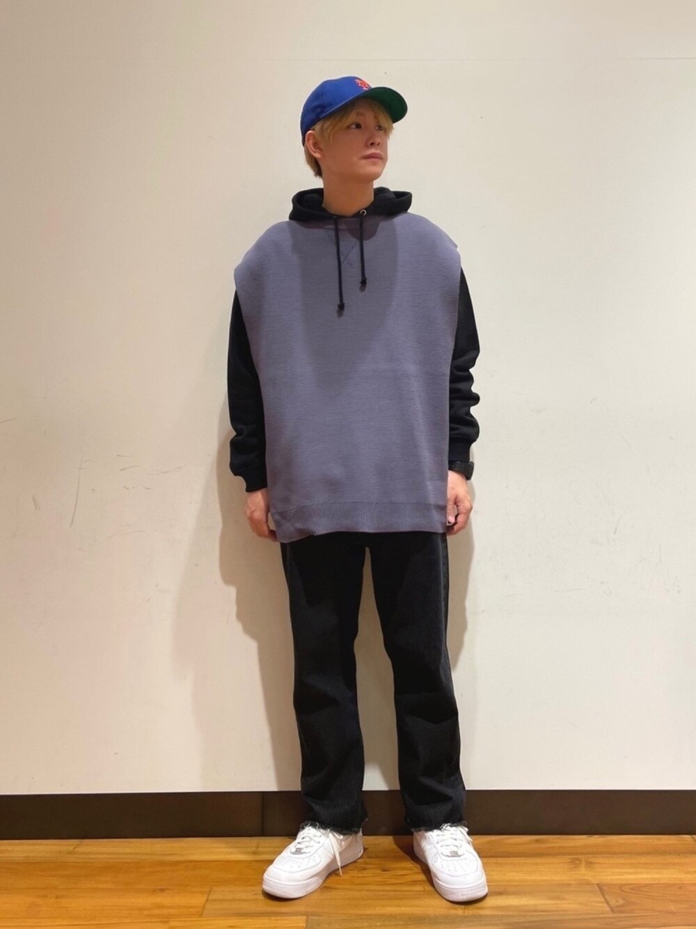 パープル系のベスト、ブラック系のデニムパンツ、ブラック系のパーカーを着用したメンズの春コーディネートの1枚目の写真