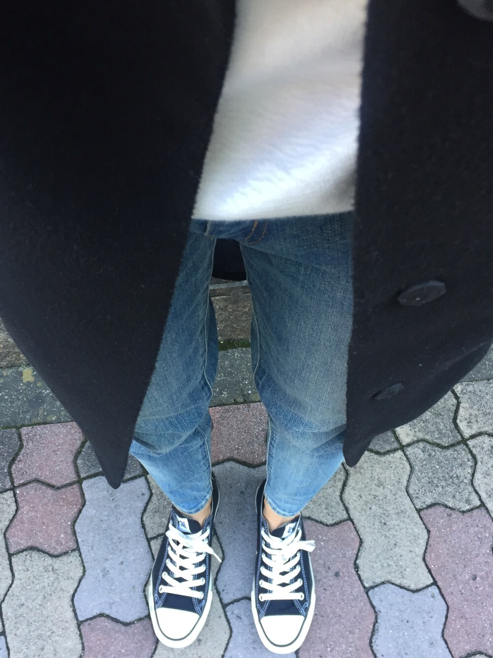 ブルー系のデニムパンツ、ブラック系のスニーカー、ブラック系のノーカラージャケットを着用したレディースの秋コーディネートの1枚目の写真