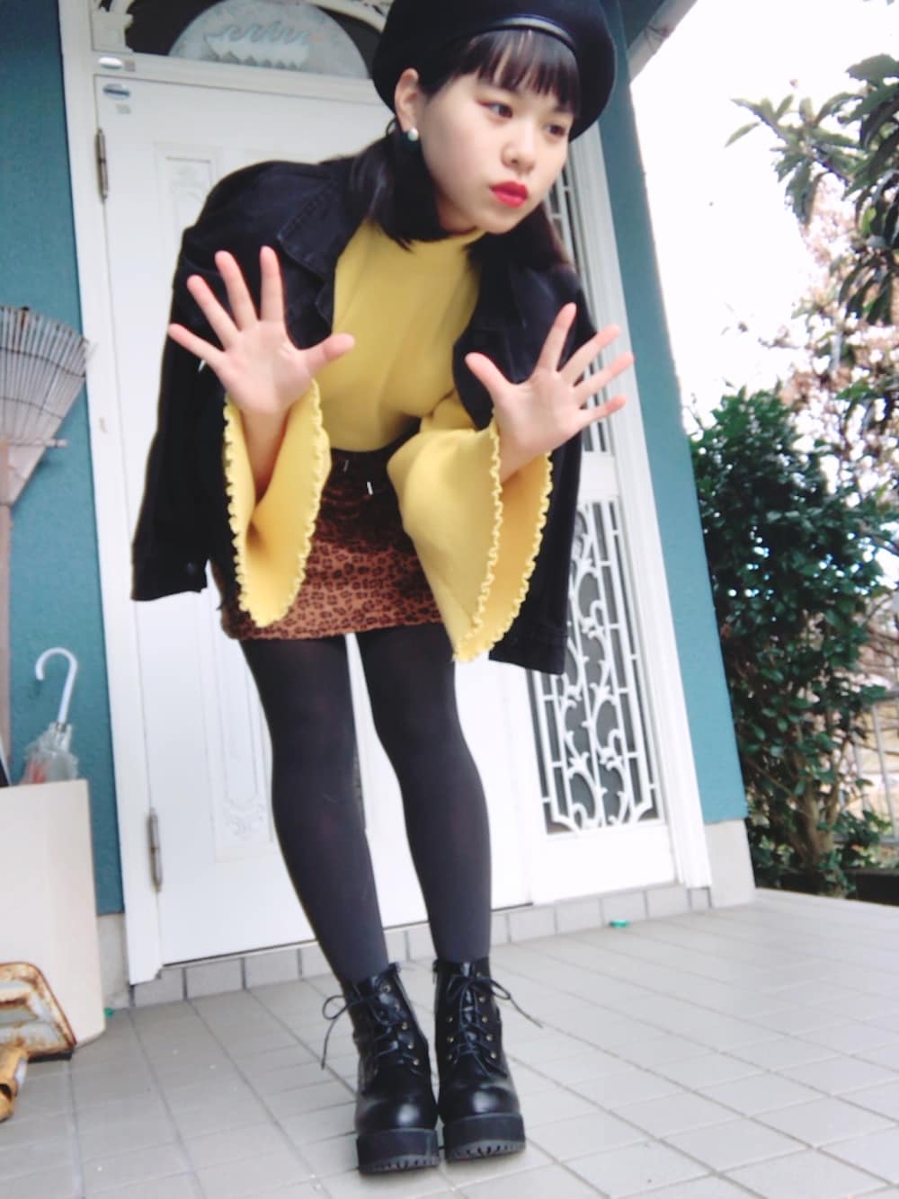 イエロー系のニット/セーター、ブラック系のブーツ、ブラウン系のスカートを着用したレディースの冬コーディネートの1枚目の写真