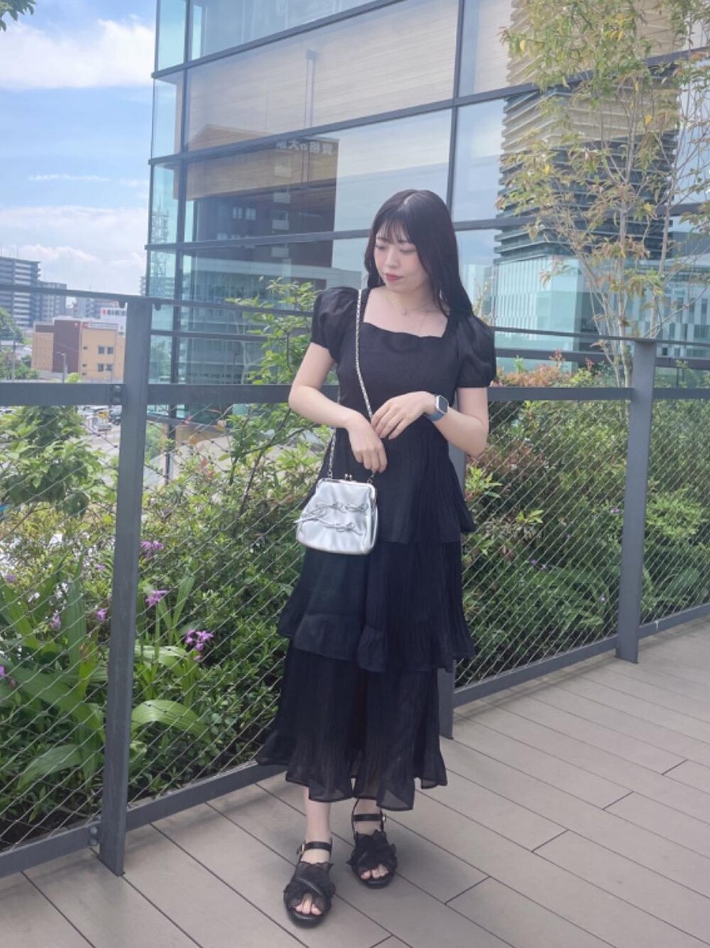 ブラック系のサンダル、ブラック系のワンピースを着用したレディースの春コーディネートの1枚目の写真