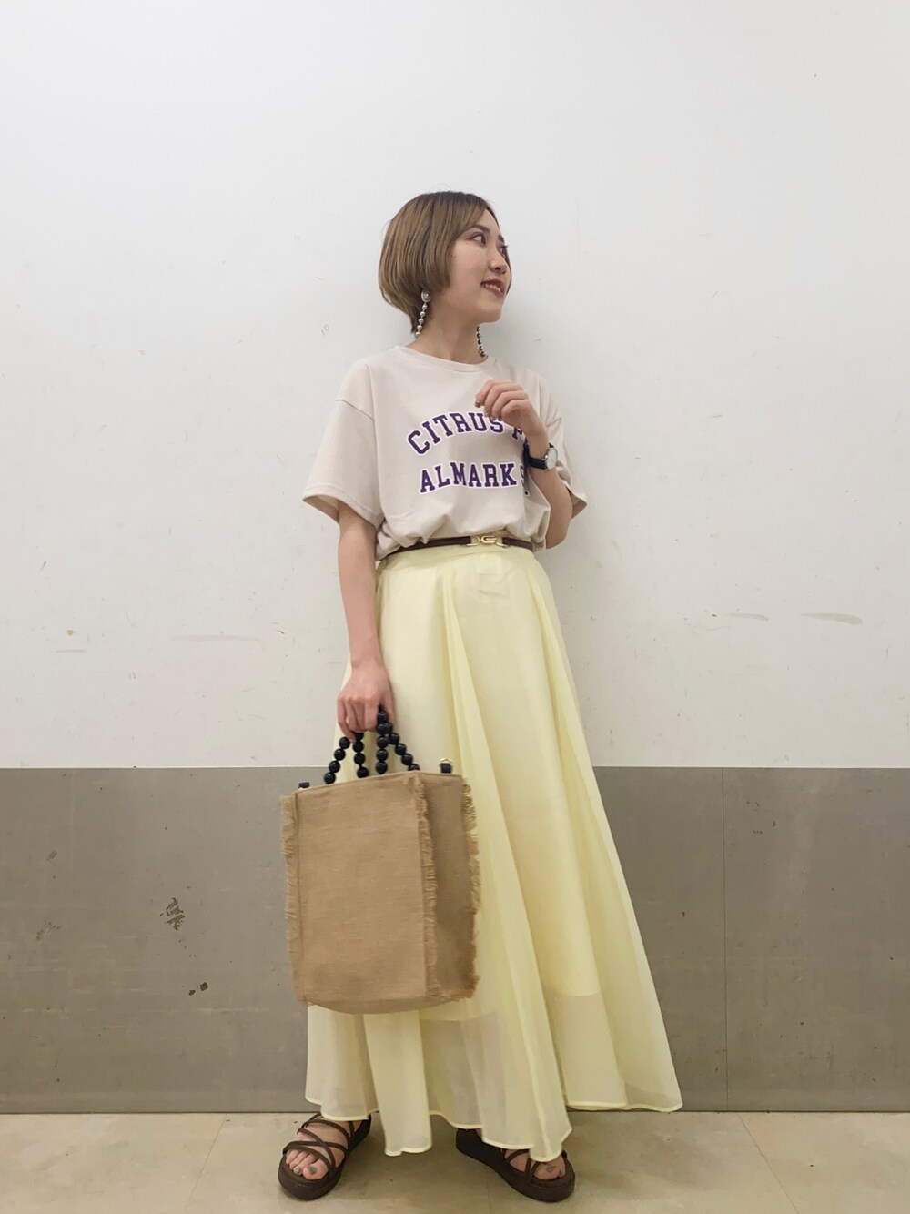 「カレッジ、Tシャツ、スカート、フレアスカート、サンダル、スポーツサンダル、大人カジュアル、シンプルコーデ、ミスティ ウーマン(mysty woman)」｜「mysty womanのカレッジロゴプリントTシャツ 950564（Tシャツ/カットソー、ベージュ系）」を使った、あくるんさん（レディース・156cm）の春コーディネートの1枚目の写真