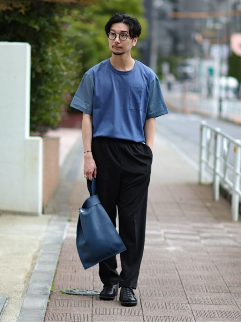 ブラック系のスニーカー、ブラック系のその他パンツ、ブルー系のハンドバッグを着用したメンズの春コーディネートの1枚目の写真