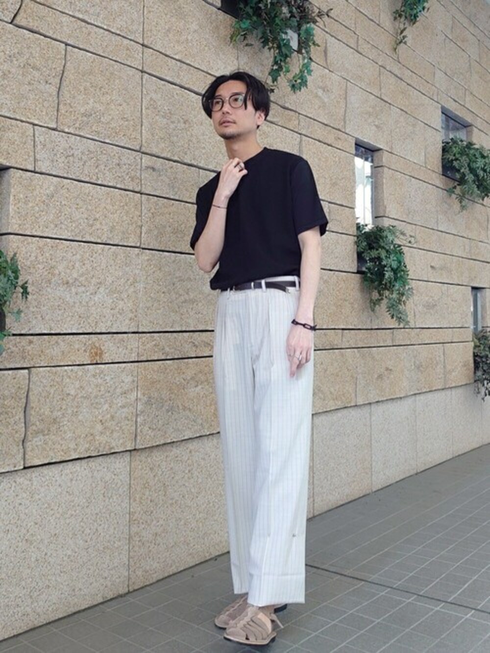 ブラック系のニット/セーター、ベージュ系のサンダル、ブラウン系のベルトを着用したメンズの夏コーディネートの1枚目の写真