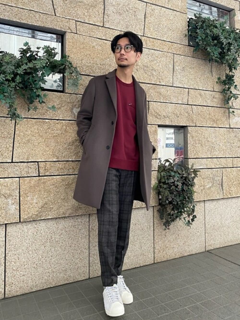 ブラウン系のチェスターコート、レッド系のTシャツ/カットソー、グレー系のスニーカーを着用したメンズの秋コーディネートの1枚目の写真