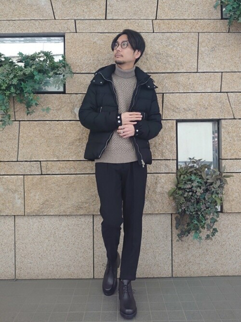 ブラック系のダウンジャケット/コート、ベージュ系のニット/セーター、ブラック系のその他パンツを着用したメンズの冬コーディネートの1枚目の写真