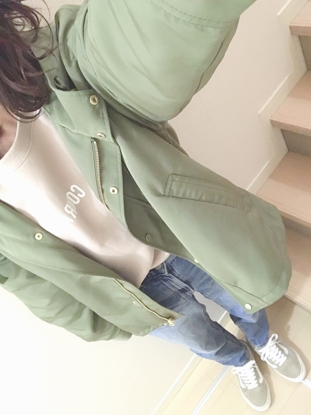 グリーン系のマウンテンパーカー、ピンク系のスウェット、ブルー系のデニムパンツを着用したレディースの春コーディネートの1枚目の写真