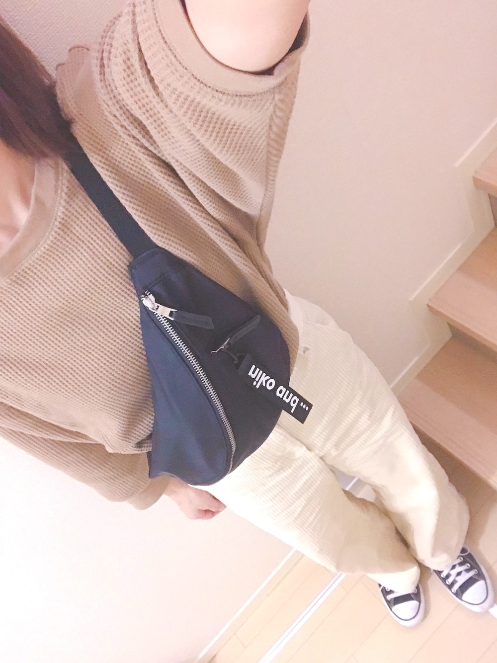 ブラック系のボディバッグ/ウエストポーチ、ベージュ系のTシャツ/カットソー、ホワイト系のパンツを着用したレディースの秋コーディネートの1枚目の写真