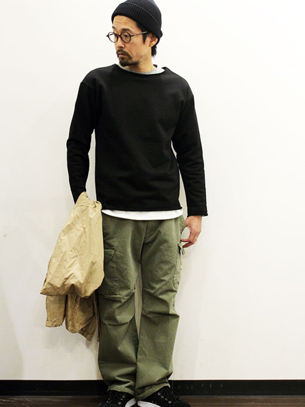 ブラック系のTシャツ/カットソー、グリーン系のカーゴパンツ、ブラック系のスニーカーを着用したメンズの冬コーディネートの1枚目の写真