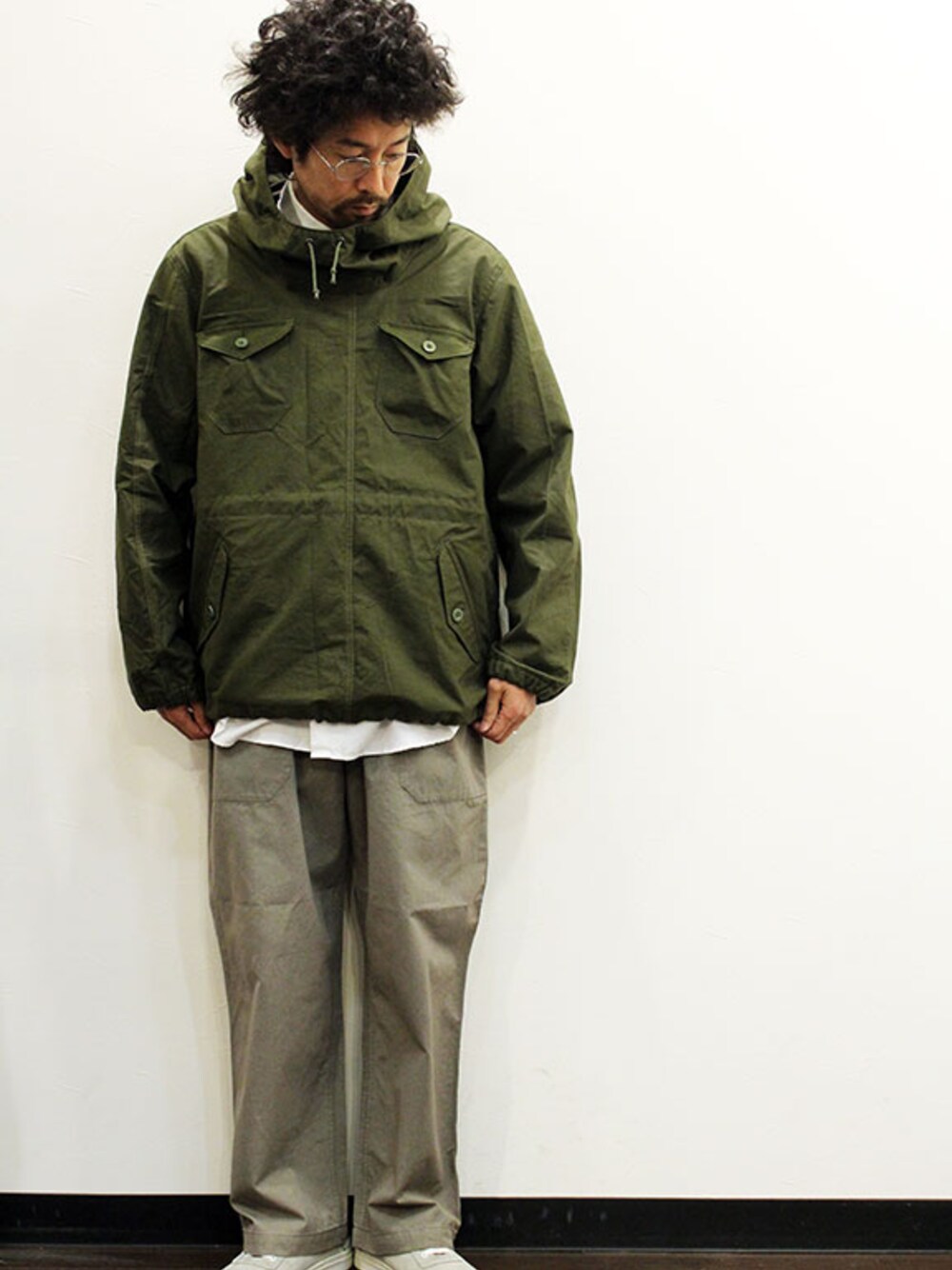 グリーン系のミリタリージャケット、ホワイト系のシャツ/ブラウス、グリーン系のチノパンツを着用したメンズの春コーディネートの1枚目の写真