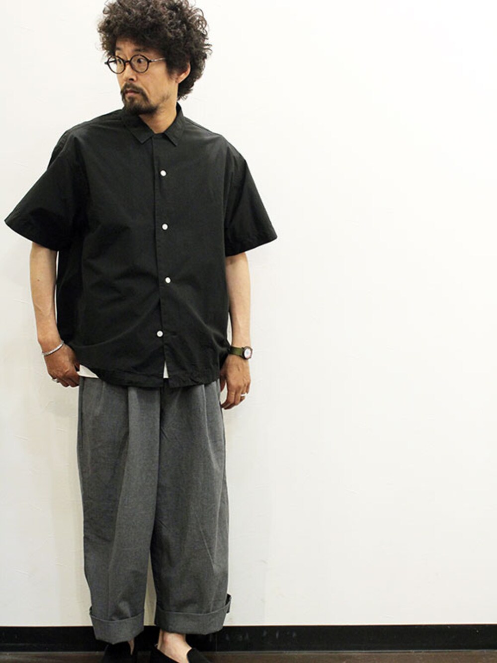 グレー系のスラックス、ブラック系のシャツ/ブラウス、その他のTシャツ/カットソーを着用したメンズの夏コーディネートの1枚目の写真