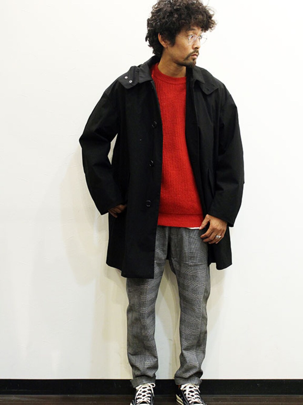 ブラック系のステンカラーコート、その他のニット/セーター、グレー系のスラックスを着用したメンズの秋コーディネートの1枚目の写真