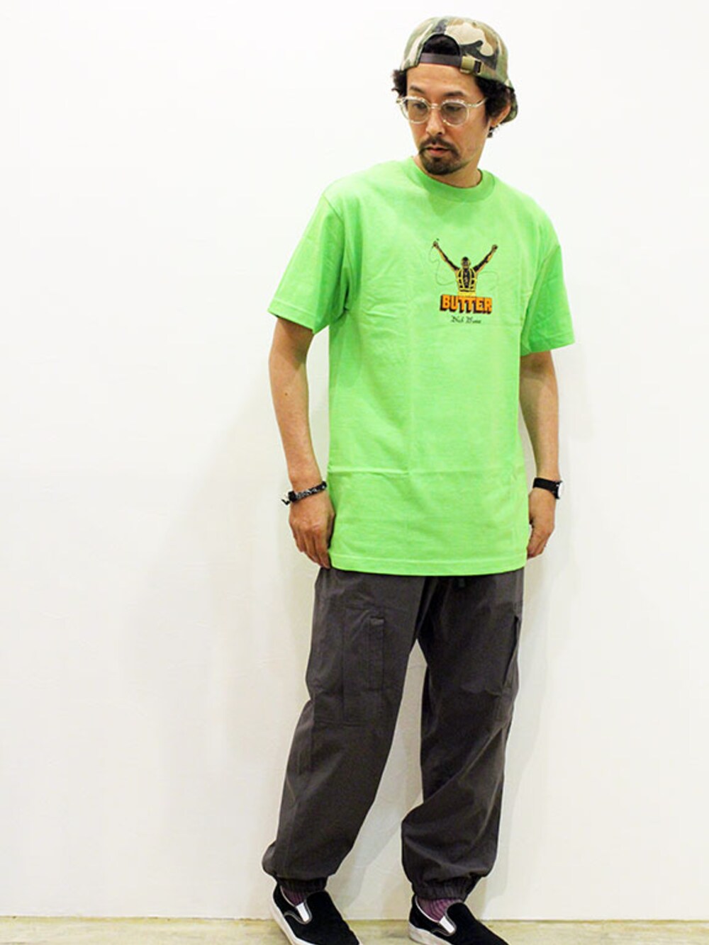 グリーン系のTシャツ/カットソー、グレー系のカーゴパンツ、ブラック系のスニーカーを着用したメンズの夏コーディネートの1枚目の写真