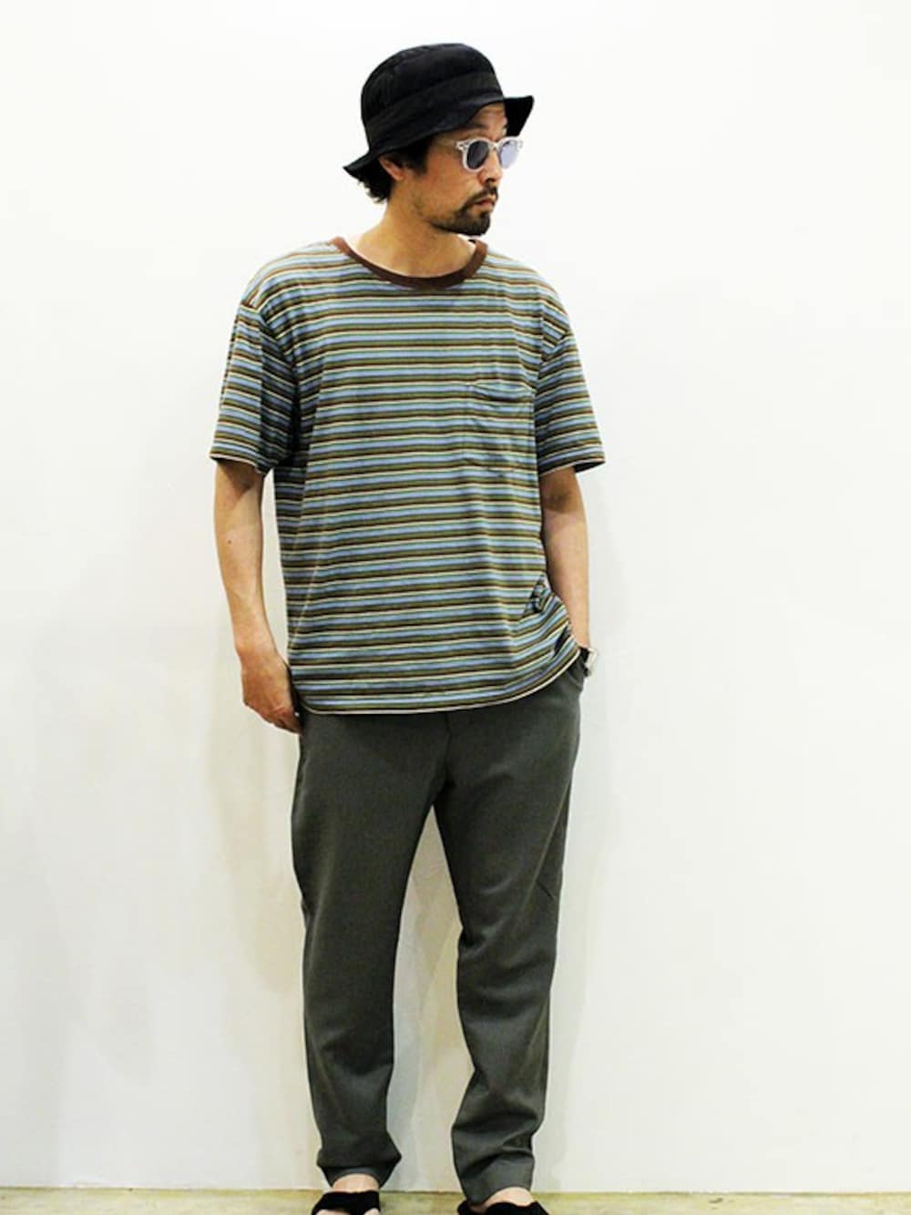 グリーン系のスラックス、ブルー系のTシャツ/カットソー、ブルー系のサンダルを着用したメンズの夏コーディネートの1枚目の写真