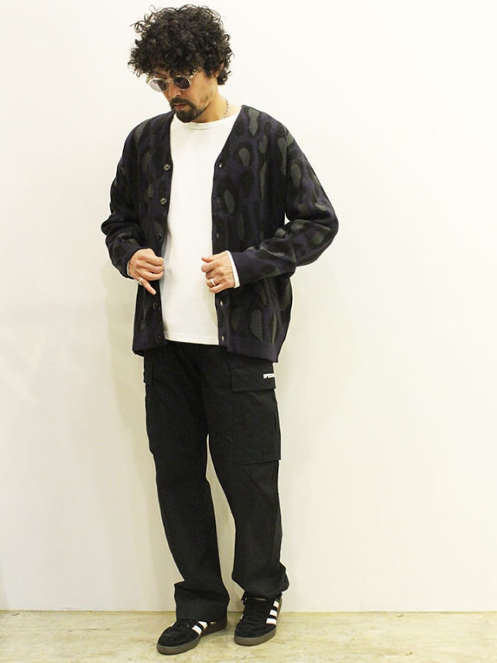 ブラック系のカーディガン/ボレロ、ホワイト系のTシャツ/カットソー、グリーン系のカーゴパンツを着用したメンズの春コーディネートの1枚目の写真