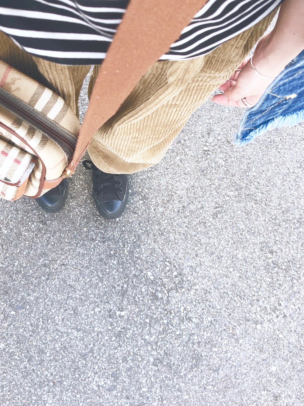 ブラック系のスニーカー、ブラウン系のショルダーバッグ、ブルー系のデニムジャケットを着用したレディースの夏コーディネートの1枚目の写真