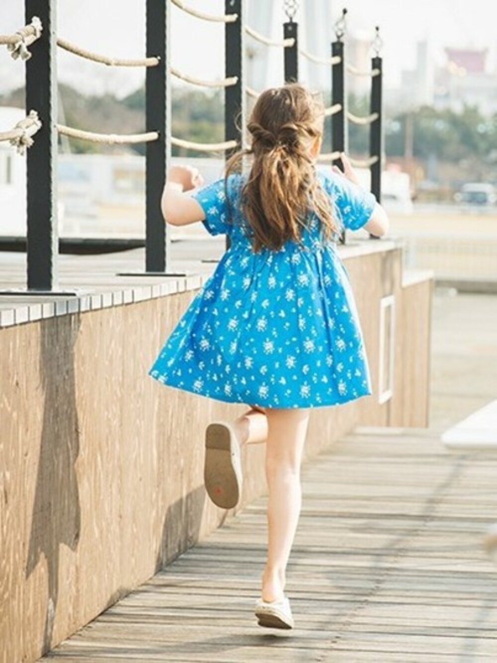 ブルー系のワンピースを着用したキッズの春コーディネートの1枚目の写真