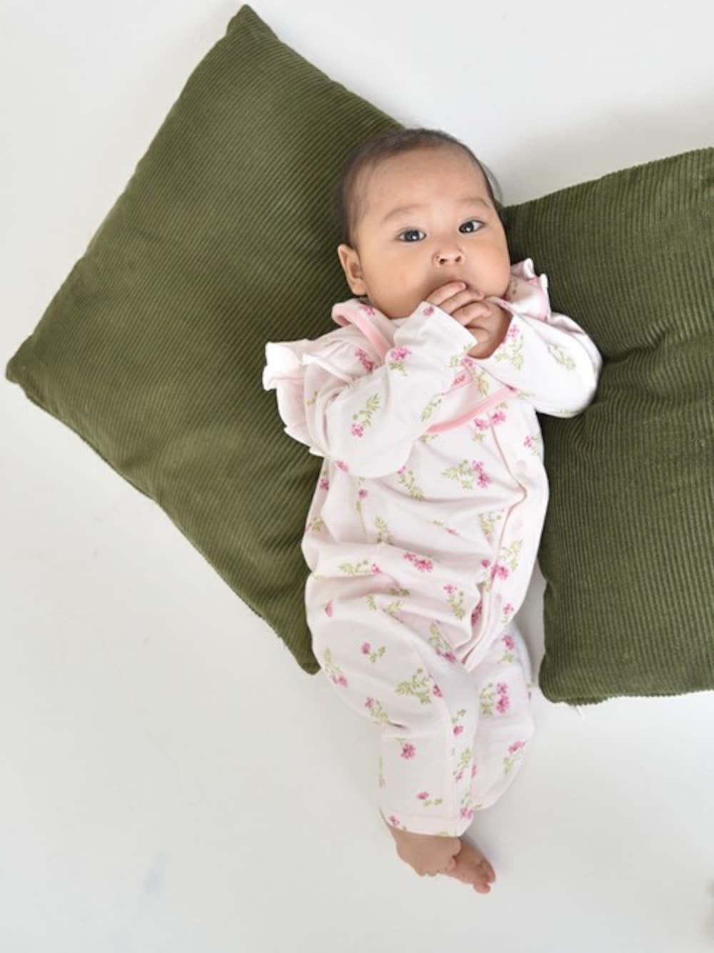 ピンク系のロンパース、ピンク系のスタイ/よだれかけを着用したキッズの夏コーディネートの1枚目の写真