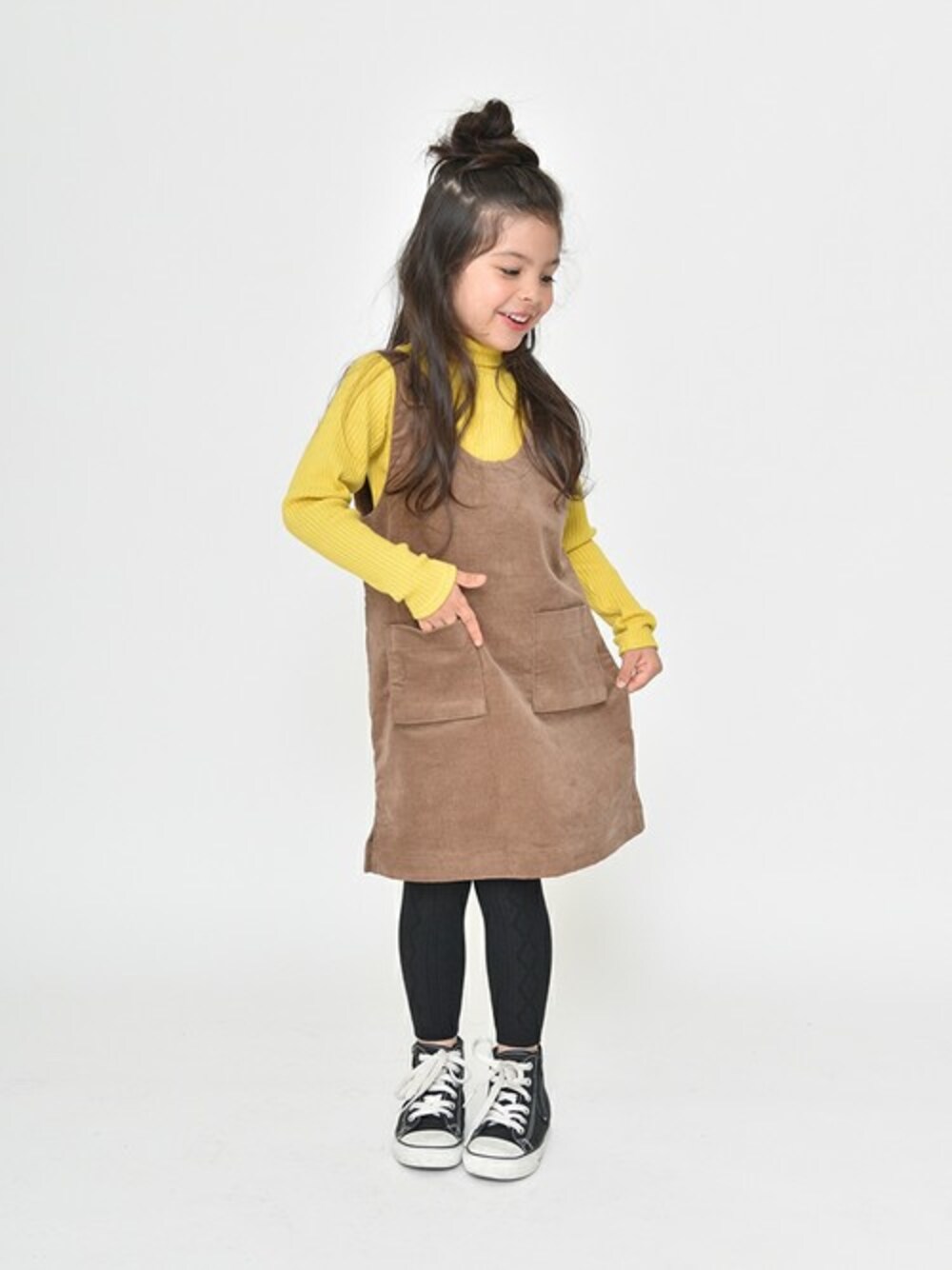 イエロー系のTシャツ/カットソー、ブラウン系のスカート、ブラック系のタイツ/ストッキングを着用したキッズの冬コーディネートの1枚目の写真