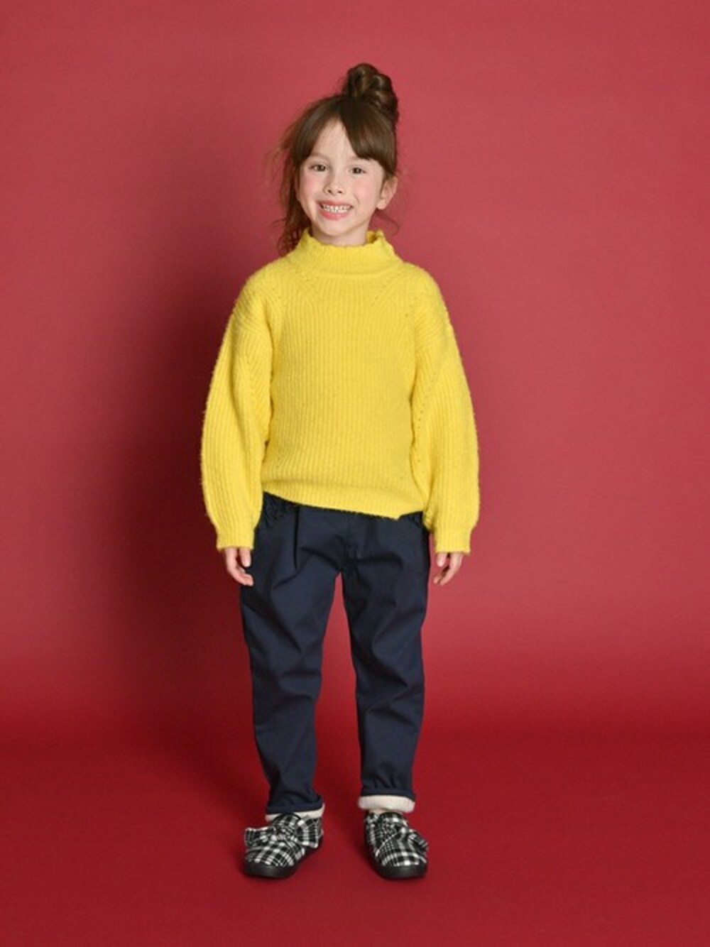 イエロー系のニット/セーター、ブルー系のその他パンツ、ホワイト系のスリッポンを着用したキッズの冬コーディネートの1枚目の写真