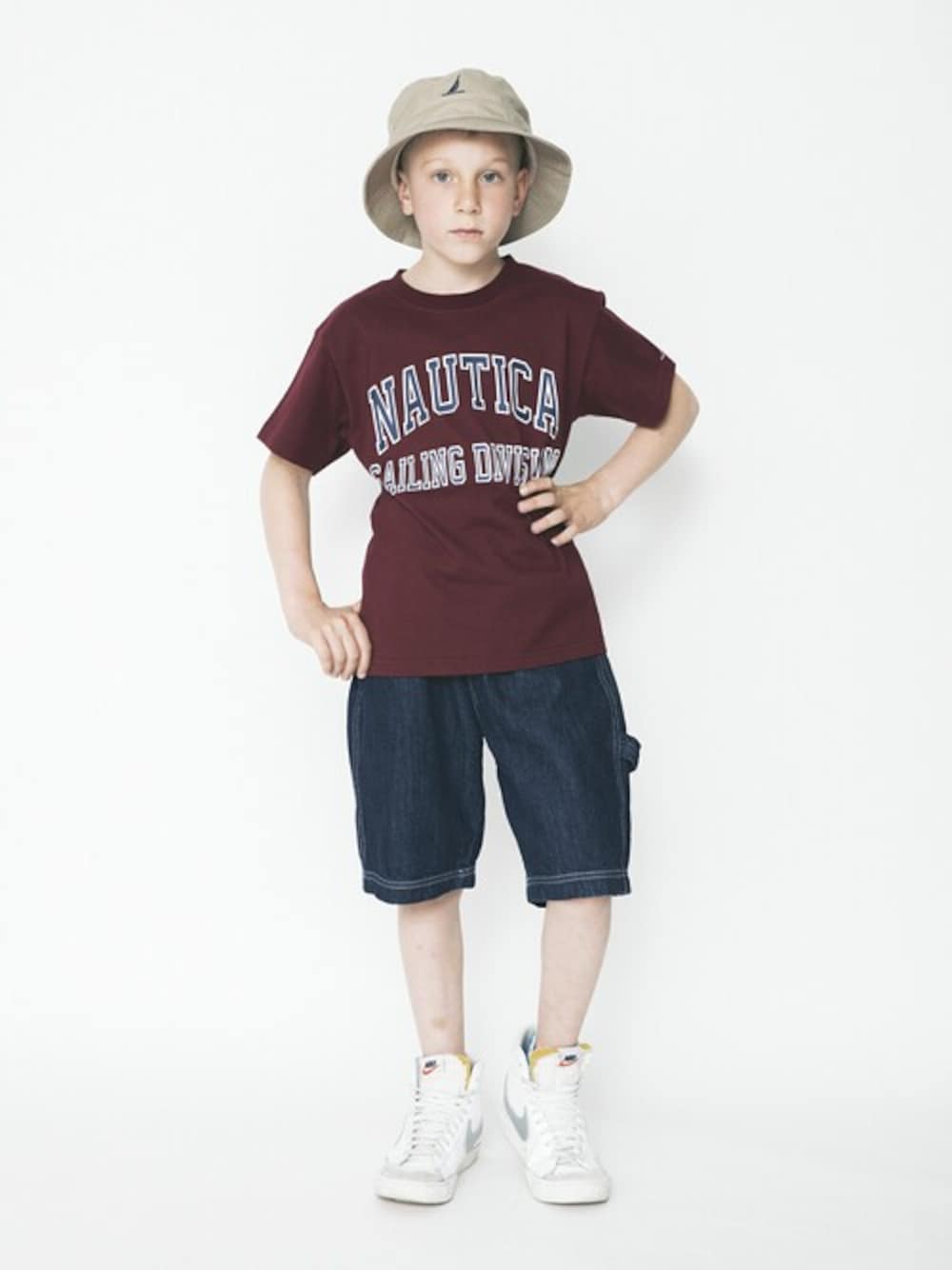 レッド系のTシャツ/カットソー、ブルー系のデニムパンツ、ベージュ系のハットを着用したキッズの春コーディネートの1枚目の写真