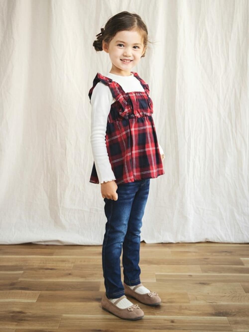 レッド系のTシャツ/カットソー、ブルー系のデニムパンツ、ブラウン系のバレエシューズを着用したキッズの秋コーディネートの1枚目の写真