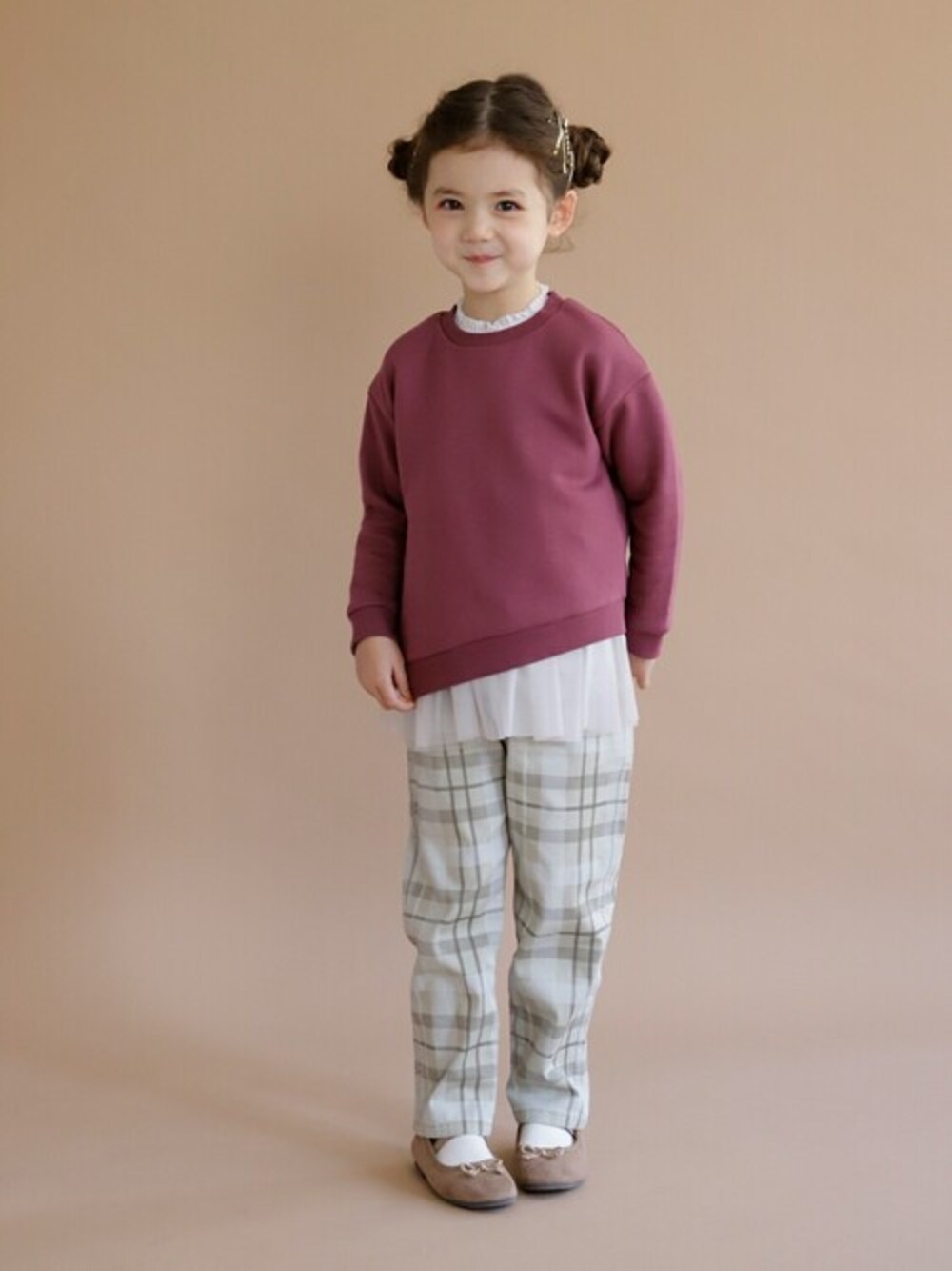 ピンク系のスウェット、ベージュ系のチノパンツ、ブラウン系のバレエシューズを着用したキッズの秋コーディネートの1枚目の写真