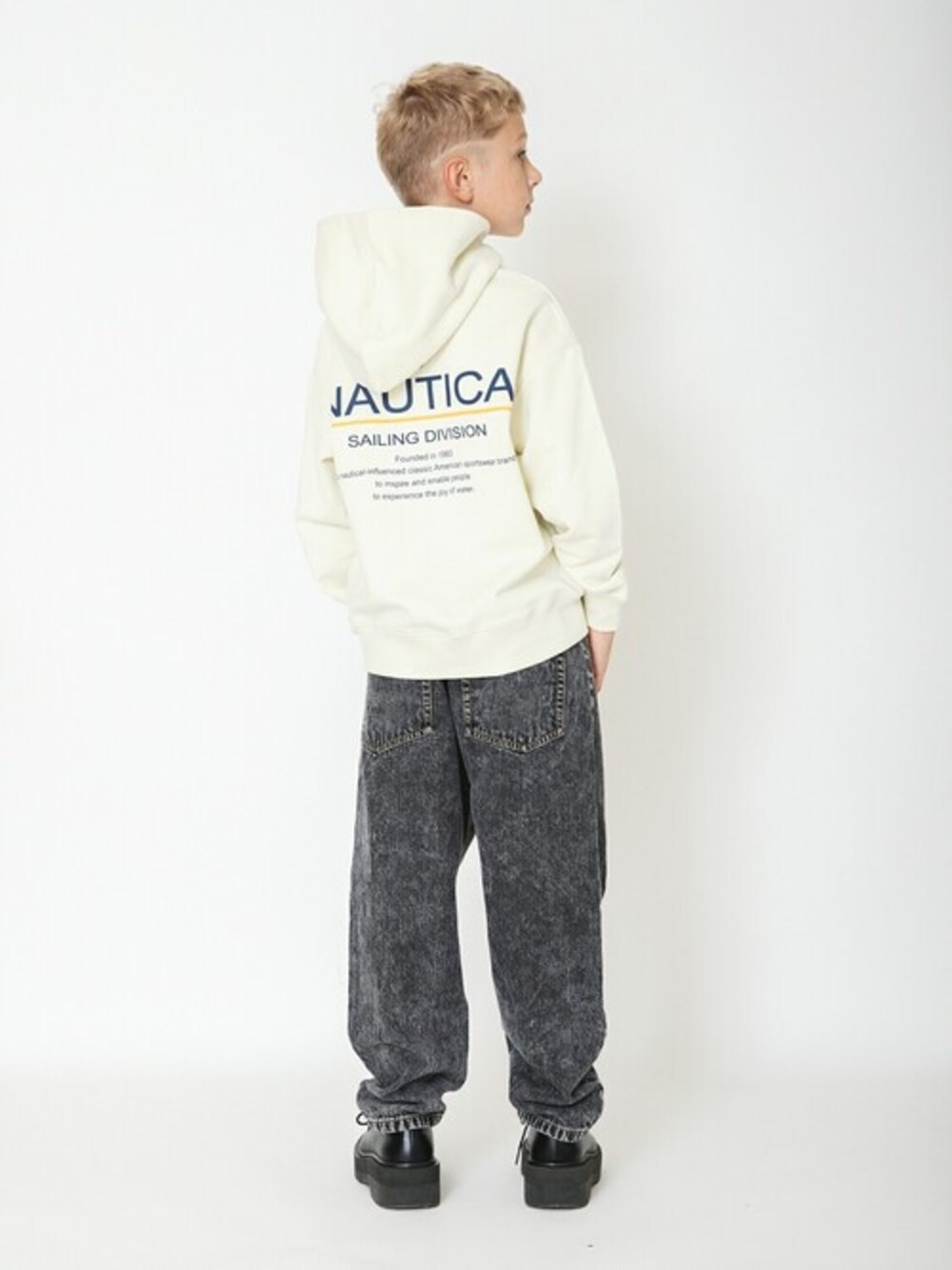 ホワイト系のパーカー、ブラック系のその他パンツを着用したキッズの冬コーディネートの1枚目の写真