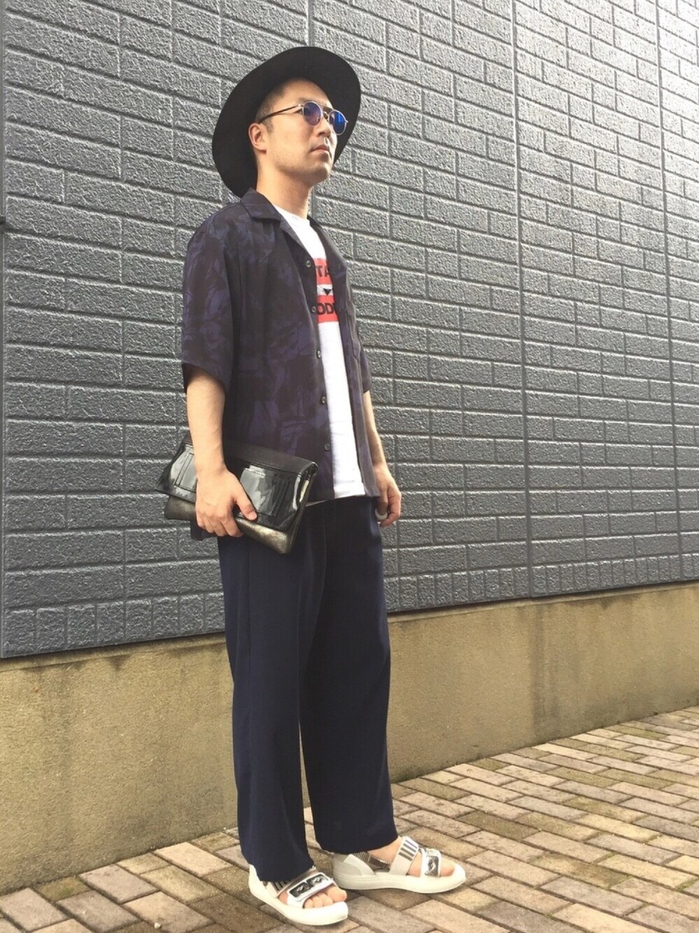 ホワイト系のTシャツ/カットソー、ブラック系のクラッチバッグ、ブルー系のその他パンツを着用したメンズの夏コーディネートの1枚目の写真