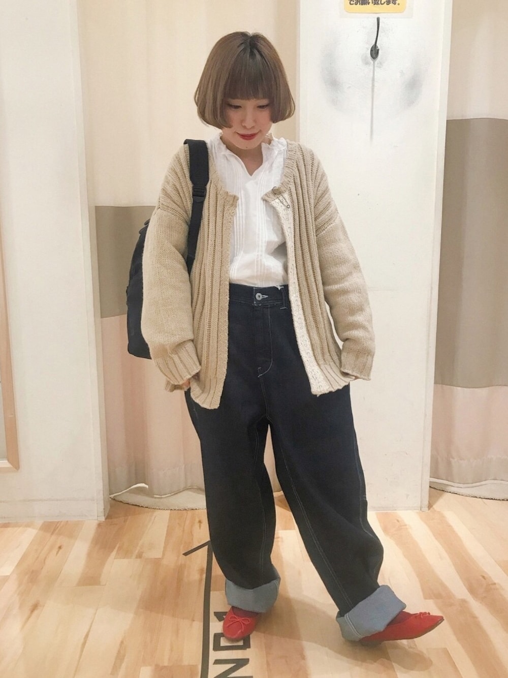 ブラック系のバックパック/リュック、ブルー系のデニムパンツ、レッド系のバレエシューズを着用したレディースの春コーディネートの1枚目の写真