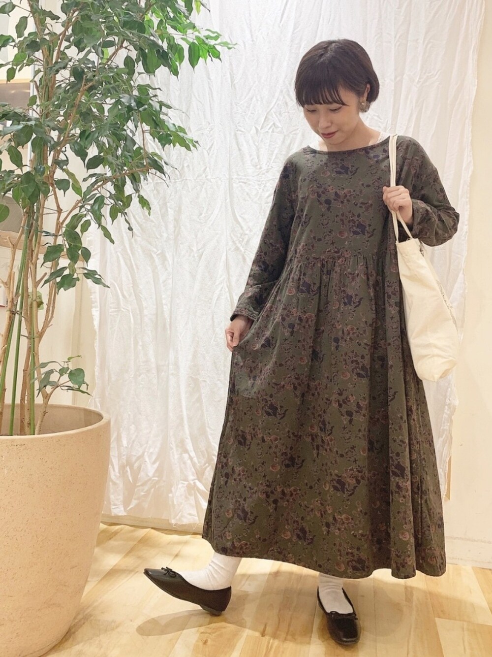 オレンジ系のワンピース/ドレス、ブラック系のバレエシューズ、ベージュ系のトートバッグを着用したレディースの秋コーディネートの1枚目の写真