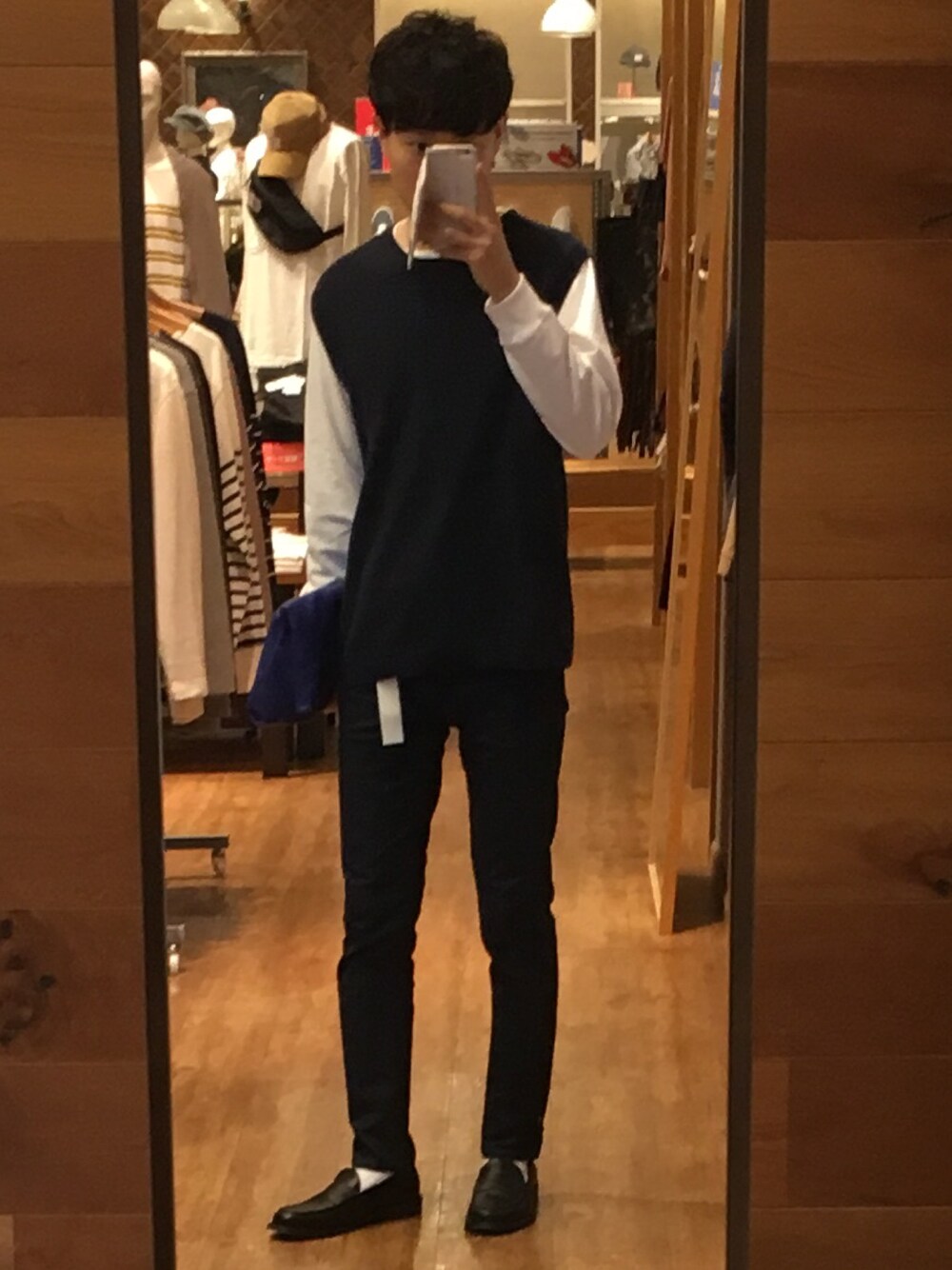 ブルー系のベスト、ホワイト系のTシャツ/カットソー、ブルー系のデニムパンツを着用したメンズの秋コーディネートの1枚目の写真