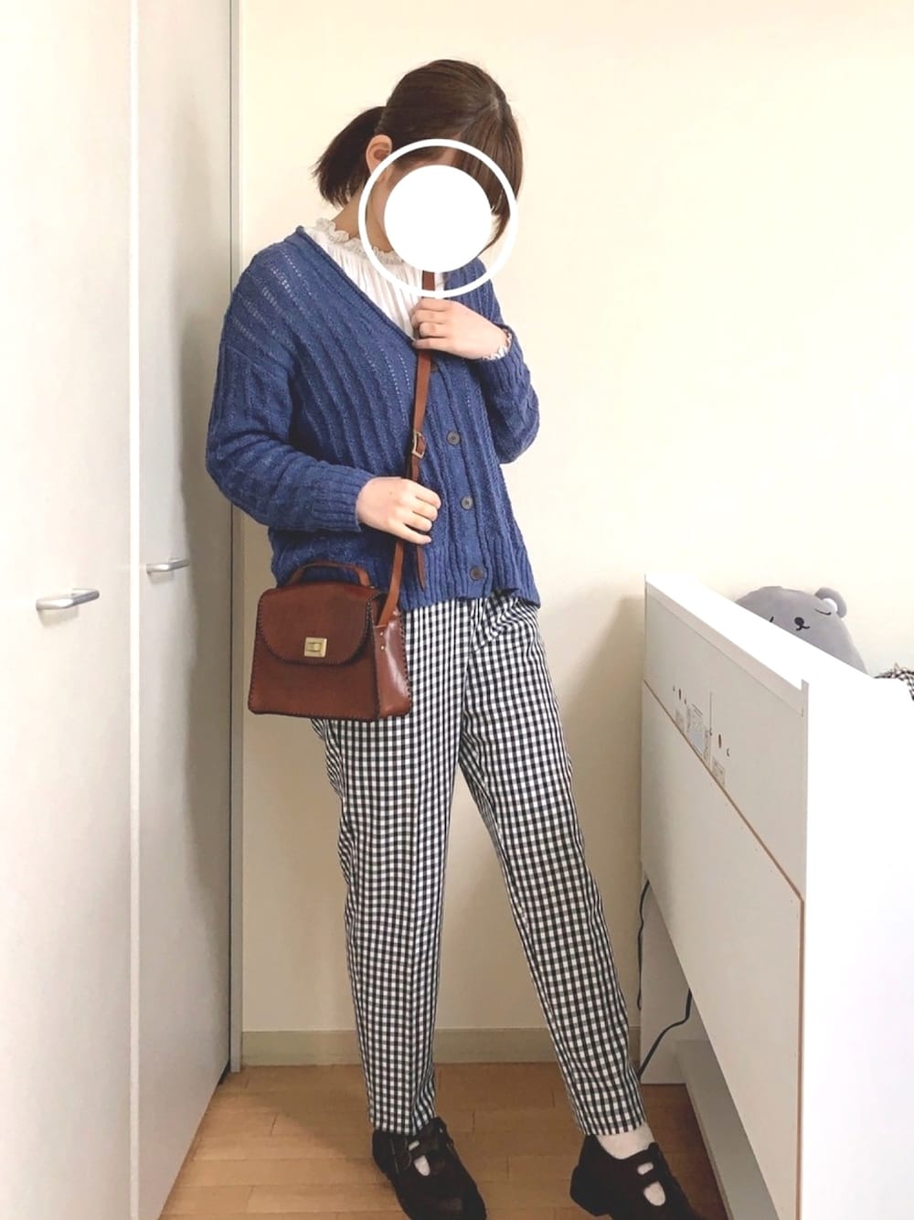 ブラウン系のバッグ、ブラック系のパンツ、ブルー系のカーディガン/ボレロを着用したレディースの春コーディネートの1枚目の写真