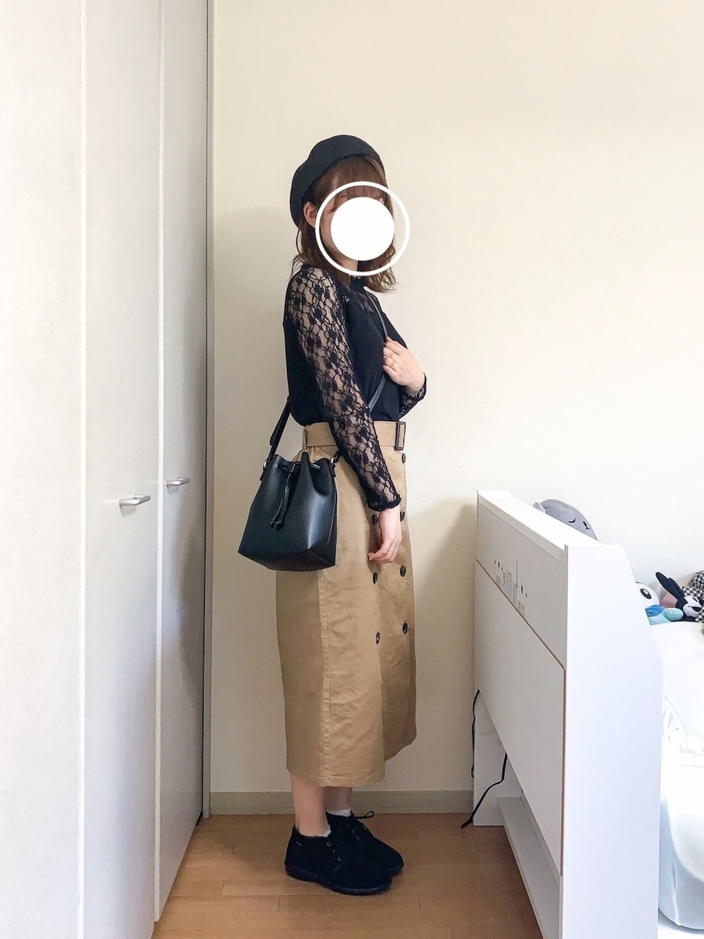 ブラック系のTシャツ/カットソー、ベージュ系のスカート、ブラック系のバッグを着用したレディースの春コーディネートの1枚目の写真