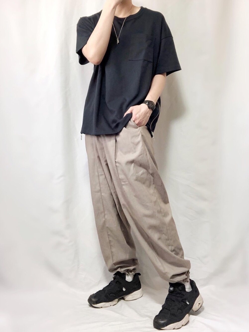 ベージュ系のスラックス、ブラック系のスニーカー、ブルー系のTシャツ/カットソーを着用したメンズの春コーディネートの1枚目の写真