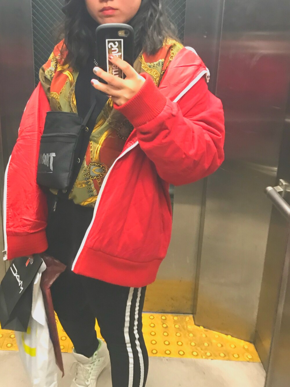 レッド系のジャケット/アウター、ブラック系のその他パンツ、ブラック系のショルダーバッグを着用したレディースの冬コーディネートの1枚目の写真