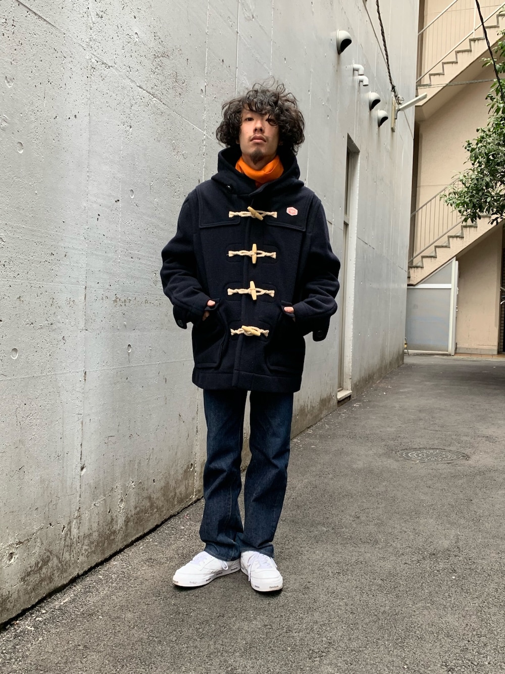 ブルー系のダッフルコート、ブルー系のデニムパンツ、ホワイト系のスニーカーを着用したメンズの秋コーディネートの1枚目の写真