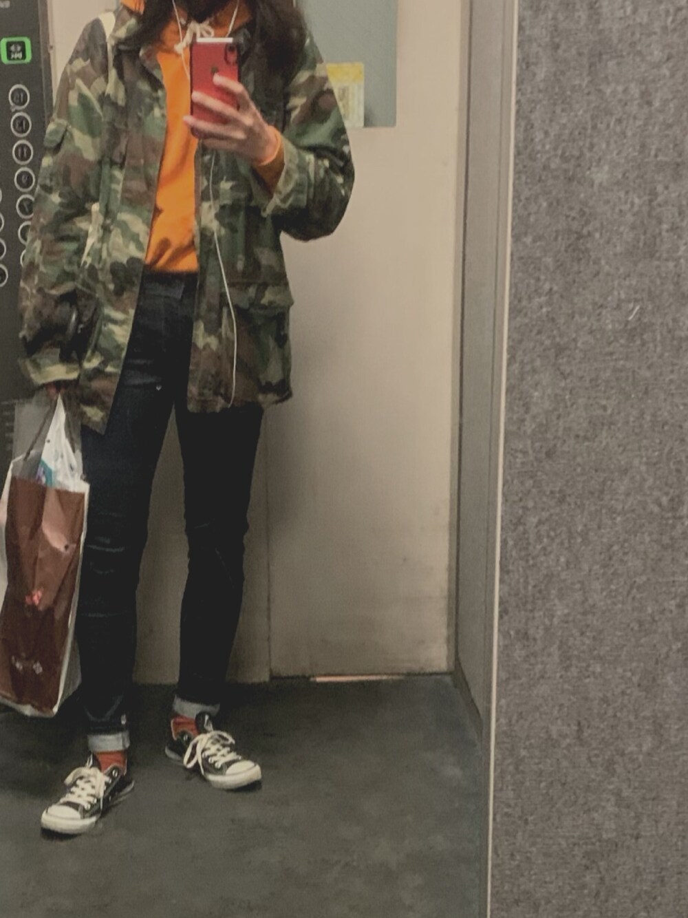 ホワイト系のトートバッグ、オレンジ系のパーカー、ブラック系のスニーカーを着用したレディースの春コーディネートの1枚目の写真