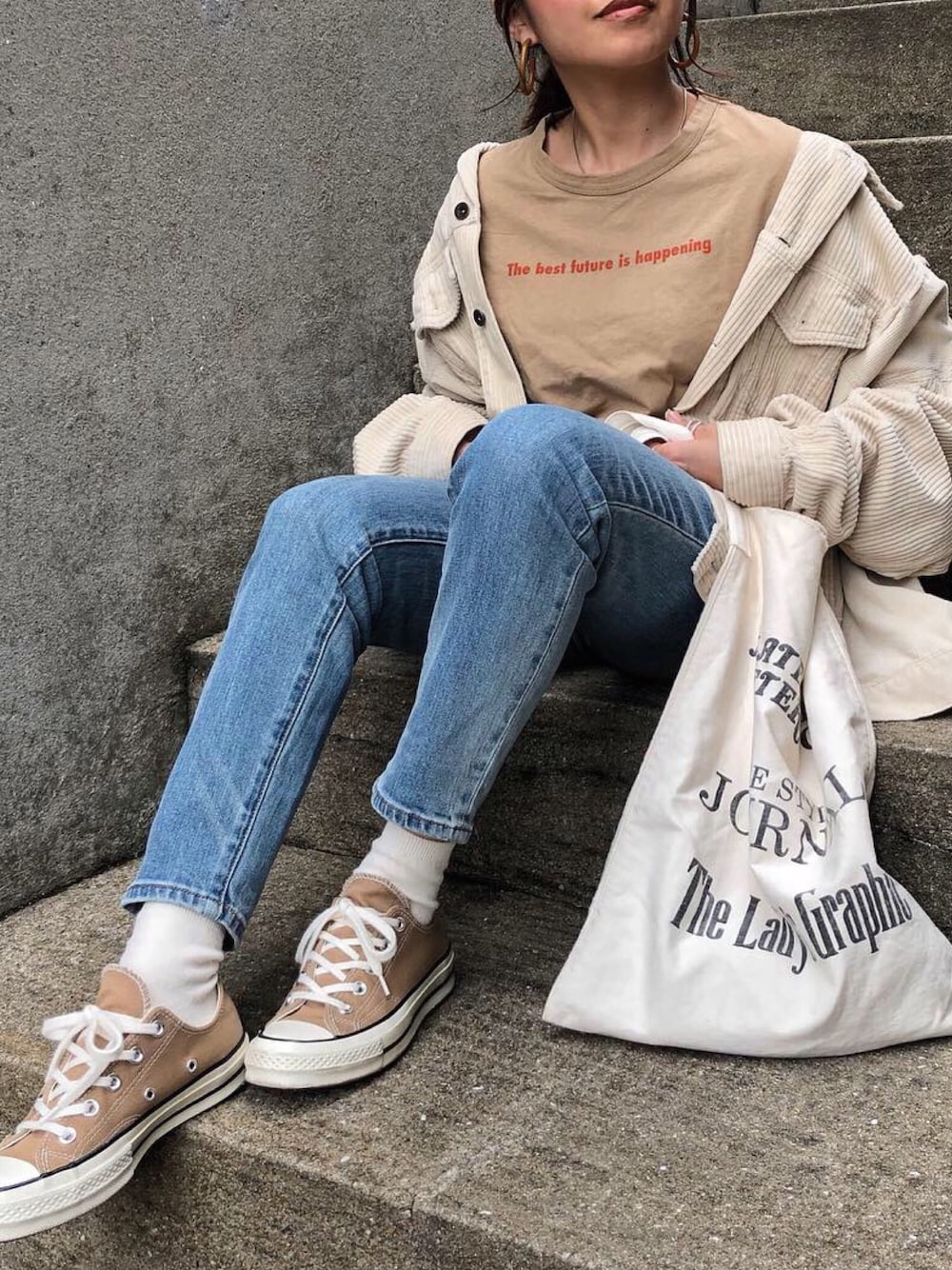 ベージュ系のブルゾン、ベージュ系のTシャツ/カットソー、ブルー系のデニムパンツを着用したレディースの春コーディネートの1枚目の写真