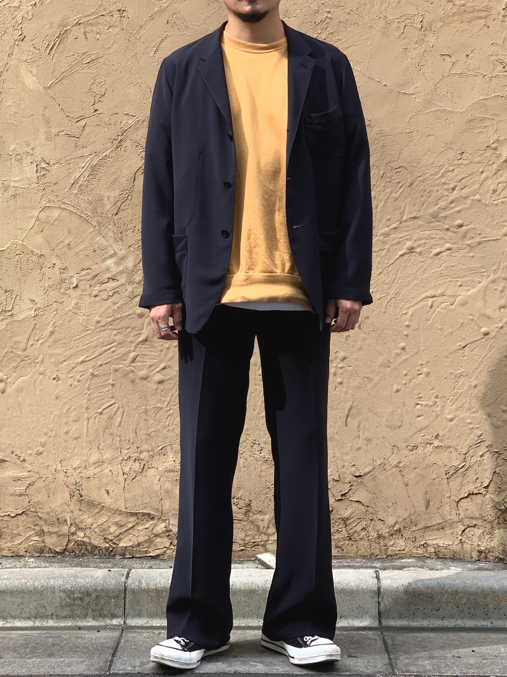 ブラック系のテーラードジャケット、イエロー系のスウェット、ホワイト系のTシャツ/カットソーを着用したメンズの秋コーディネートの1枚目の写真