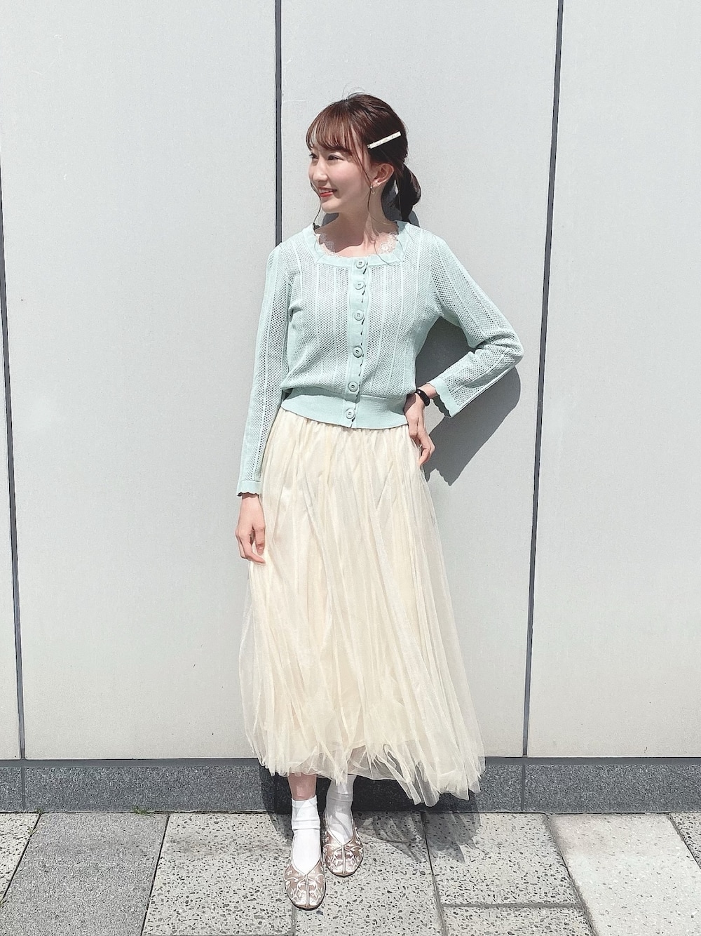 グリーン系のカーディガン/ボレロ、ベージュ系のパンプス、ホワイト系のその他を着用したレディースの春コーディネートの1枚目の写真