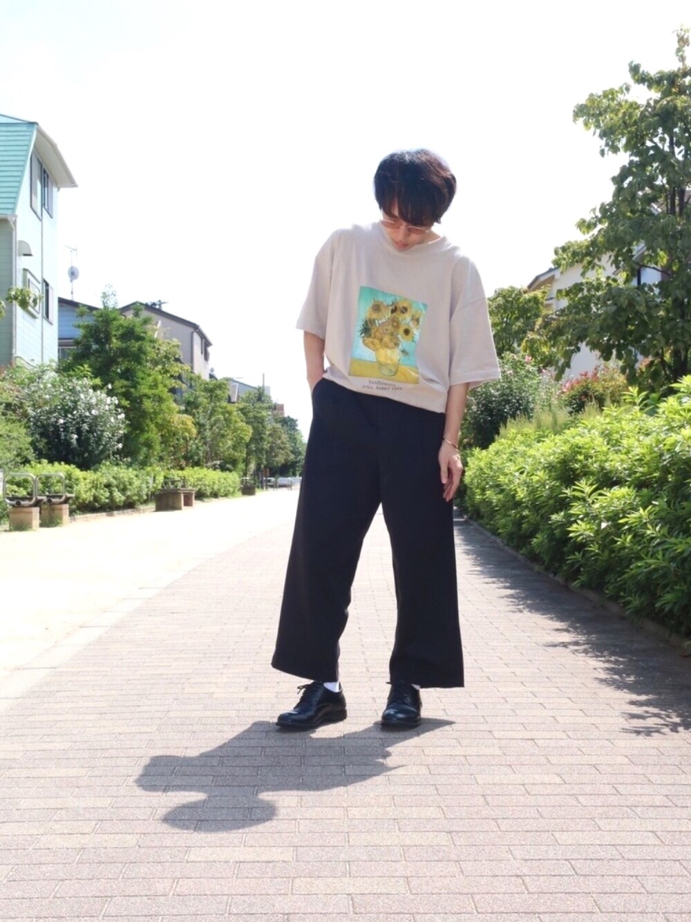 ブラウン系のTシャツ/カットソー、ブラック系のスラックス、ブラック系のドレスシューズを着用したメンズの夏コーディネートの1枚目の写真