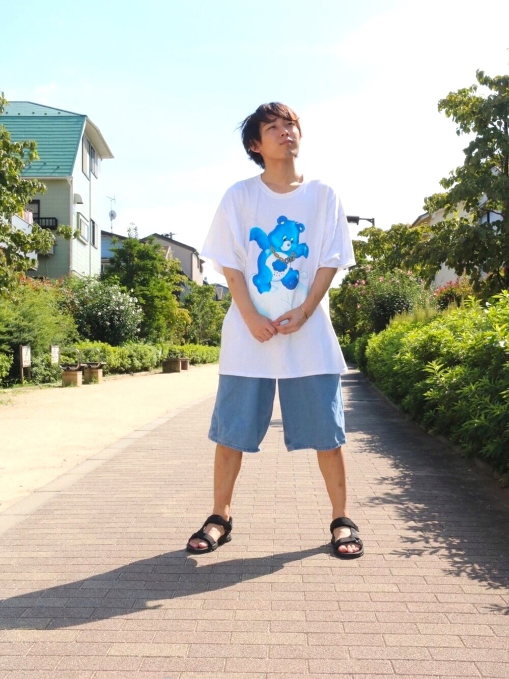 ホワイト系のTシャツ/カットソー、ブルー系のデニムパンツ、ブラック系のサンダルを着用したメンズの夏コーディネートの1枚目の写真