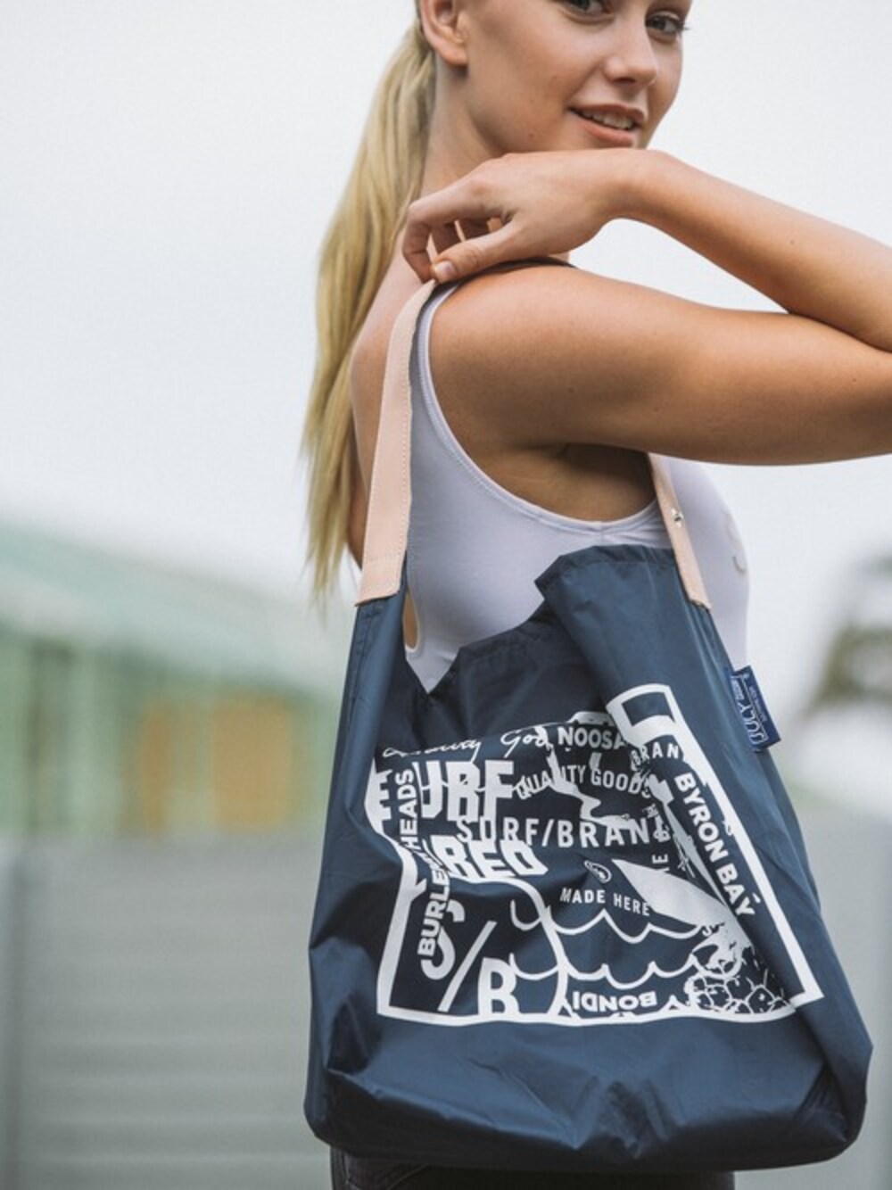 ブルー系のショルダーバッグ、ブラック系のデニムパンツ、イエロー系のヘアゴムを着用したレディースの冬コーディネートの1枚目の写真