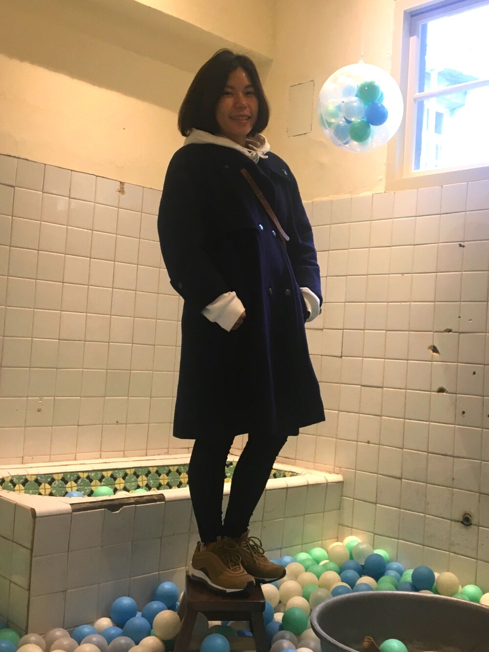 ホワイト系のパーカー、ブラウン系のショルダーバッグ、ブラック系のその他パンツを着用したレディースの春コーディネートの1枚目の写真